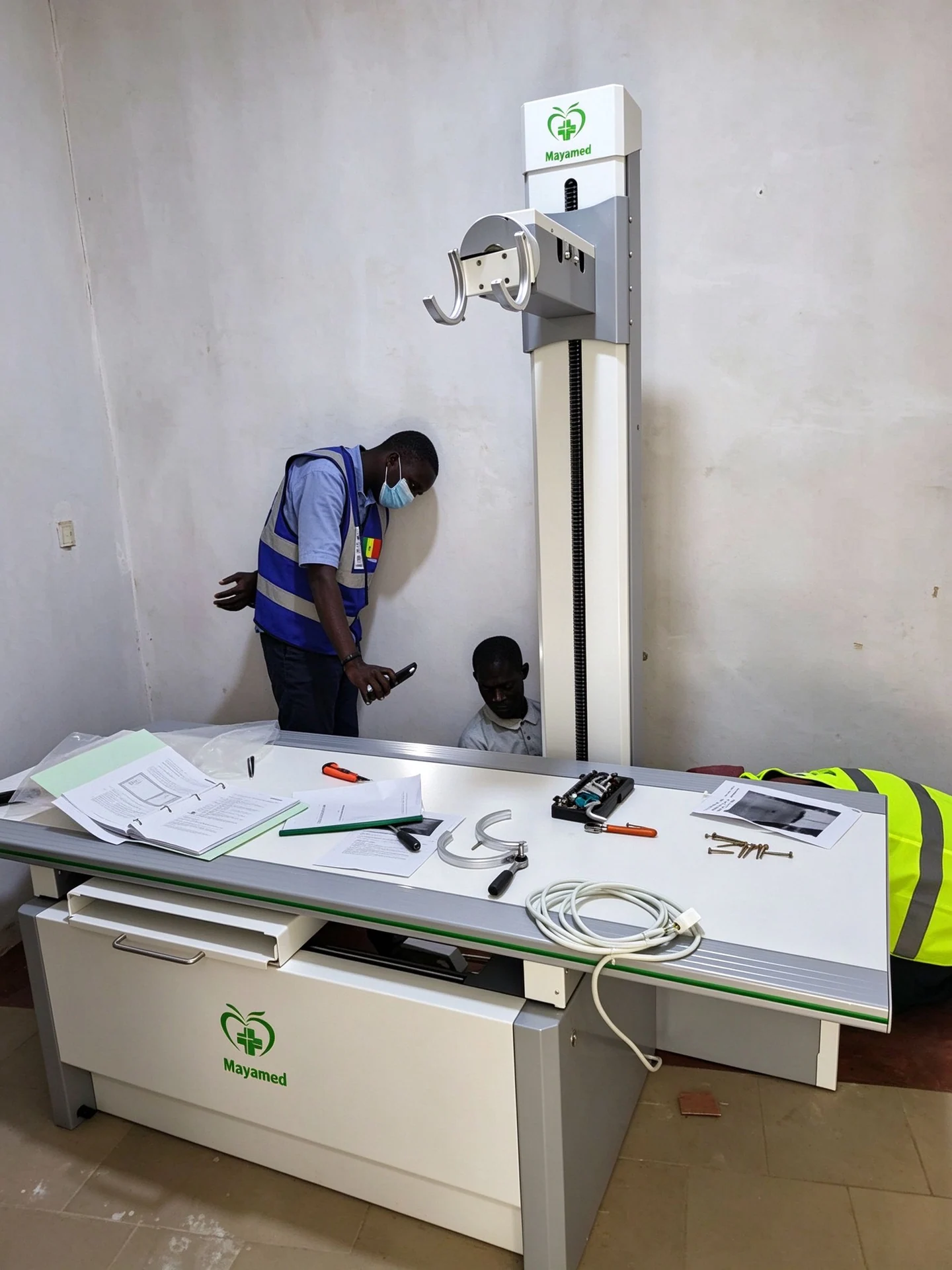 Installation team beside the X-ray stand and examination table in Senegal.